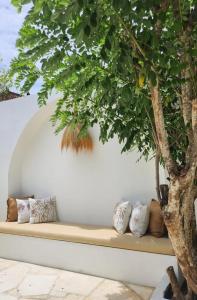 a bench with pillows sitting next to a tree at Kingfisher Beach Resort-Yala Safari in Kirinda