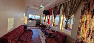 a living room with a couch and some windows at appart villa galactik pegasus in Aourir