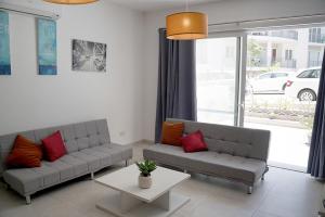 a living room with two couches and a table at Hillock Residence Marsalforn in Marsalforn