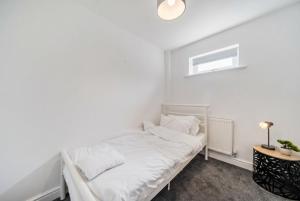 a white bedroom with a bed and a table at St John's Flats, Newsome in Huddersfield +32 photos