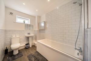a bathroom with a tub and a toilet and a sink at St John's Flats, Newsome in Huddersfield