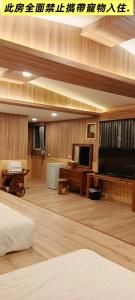 a large living room with a television and a bed at 薔薇谷 民宿字108號 in Fuxing