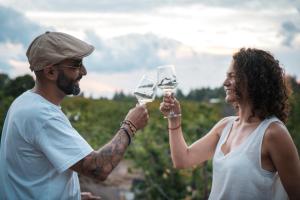 a man and a woman holding glasses of wine at Bali Andino Experience in Ciudad Lujan de Cuyo