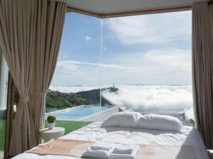 a bedroom with a bed and a window with a view at รีทรีท ภูทับเบิก in Ban Maeo Thap Boek