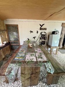 a wooden table in a room with birds on the wall at FARE Tatahi in Parea