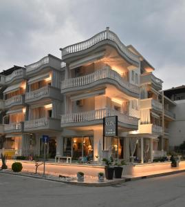 a large white building with a sign in front of it at Epavlis Luxury apts in Leptokarya