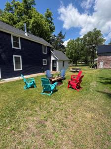 a group of chairs sitting in the grass in front of a house at The Perfect Match River Retreat in Buffalo City