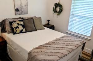 a bedroom with a large bed with pillows and a window at Private Beach, secluded! in Covington