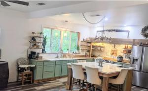 a kitchen with green cabinets and a table with chairs at Private Beach, secluded! in Covington