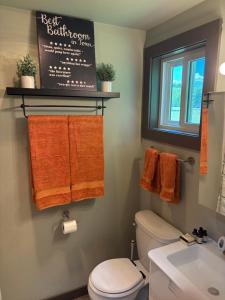 a bathroom with a toilet and a sink and towels at The Perfect Match River Retreat in Buffalo City +5 photos
