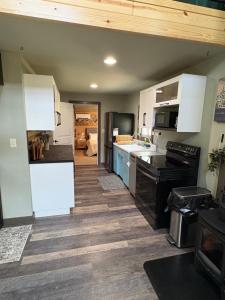 a kitchen with white cabinets and a wooden floor at The Perfect Match River Retreat in Buffalo City