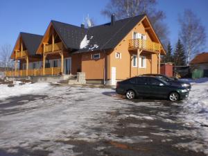 a car parked in a parking lot in front of a house at Apartmány Eva Frymburk in Frymburk