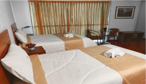a hotel room with three beds with towels on them at HOTEL MURCIA AREQUIPA in Arequipa