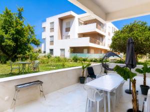 a balcony with a white table and chairs and a building at Nour House Imi Ouaddar in Agadir nʼ Aït Sa