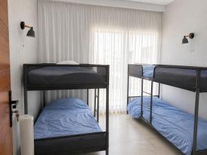 two bunk beds in a room with a window at Nour House Imi Ouaddar in Agadir nʼ Aït Sa +12 photos