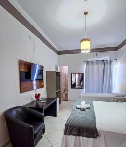 a bedroom with a bed and a chair and a desk at Iter Hotel in Rifaina