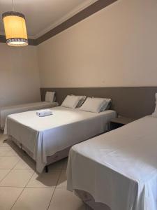 a bedroom with two beds and a chandelier at Iter Hotel in Rifaina