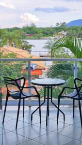 two chairs and a table on a balcony with a view at Iter Hotel in Rifaina
