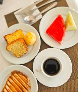 a table with plates of food and a cup of coffee at Iter Hotel in Rifaina