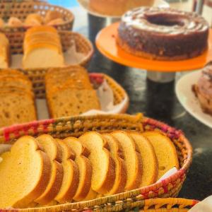 a table topped with baskets of bread and cakes at Iter Hotel in Rifaina +1 photo