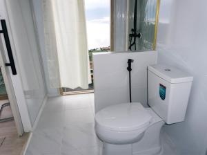 a white bathroom with a toilet and a window at รีทรีท ภูทับเบิก in Ban Maeo Thap Boek