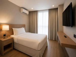a hotel room with a bed and a television at Teles Plaza Hotel in Macacos