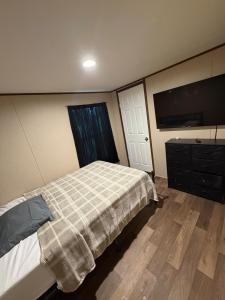a bedroom with a bed and a dresser and a television at The Relaxation Haven in McRae
