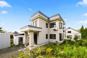 a white house with a gambrel roof at The Crane Sanctuary Kamifurano in Kami-furano