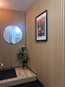 a room with a striped wall with a picture and a plant at Studio 156 in Boussu