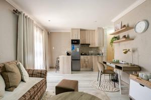 a living room with a couch and a kitchen at Executive en-Suite, cozy, comfy and spacious in Baragwanath