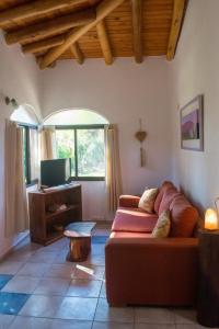 a living room with a couch and a tv at Casa Armonía in Villa Las Rosas