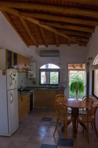a kitchen with a table and chairs and a refrigerator at Casa Armonía in Villa Las Rosas