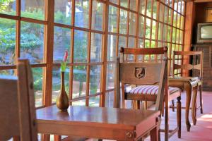 a room with two chairs and a table with a vase at Chikurinin Gunpoen in Yoshino
