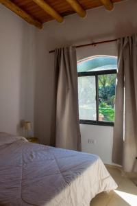 a bedroom with a bed and a window at Casa Armonía in Villa Las Rosas