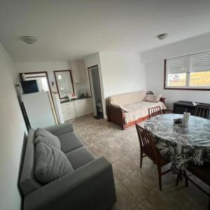 a living room with a couch and a table and a bed at Casa a pie de playa in Mar de Cobo