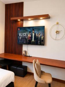 a tv hanging on a wall in a bedroom at The Narci Suites in Manila +4 photos