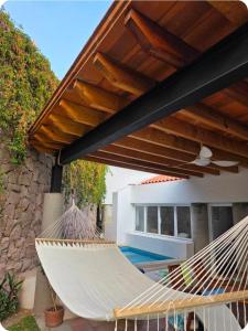 a pair of hammocks under awning next to a pool at Casa Golondrina in Xochitepec