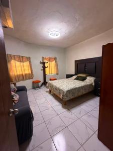 a bedroom with a bed and a couch at Casa Rivota in Delicias