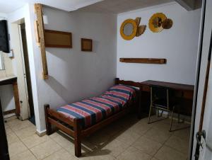 a small room with a bed and a desk at La Vecindad in Córdoba