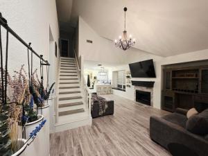 a living room with a staircase and a fireplace at North Shore Lake Community in The Colony