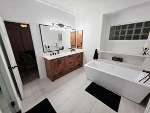 a bathroom with a large white tub and a sink at North Shore Lake Community in The Colony +33 photos