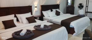 a hotel room with two beds with brown and white at Gotrika Valley Gesst in Ella