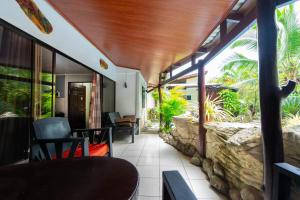 a patio with a stone wall and a table and chairs at Casa Caribbean Coconut in Cahuita