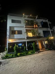 a white apartment building at night with lights at Résidence MBK Suite in Ziguinchor