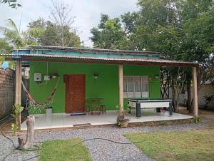 a green house with a ping pong table in front at Casa Alter do Chão Com piscina in Santarém