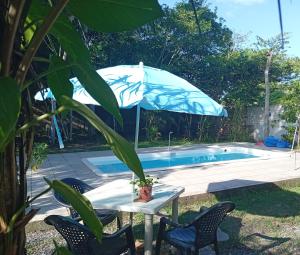 a table with an umbrella next to a pool at Casa Alter do Chão Com piscina in Santarém