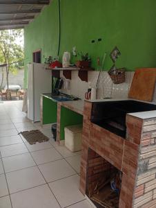 a kitchen with green walls and a white refrigerator at Casa Alter do Chão Com piscina in Santarém