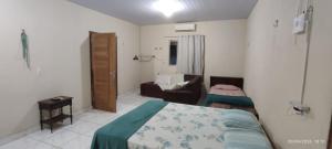 a small bedroom with a bed and a couch at Casa Alter do Chão Com piscina in Santarém +12 photos