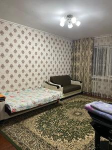 a living room with a bed and a couch at Грин сити in Balykchy