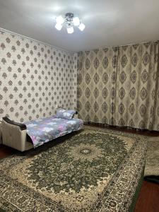 a bedroom with a bed and a rug at Грин сити in Balykchy +2 photos